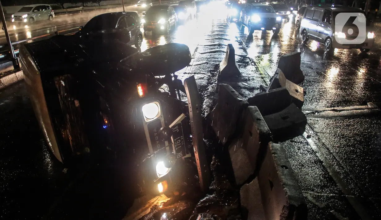 Sebuah mobil jenis jeep terguling di depan gerbang Tol Tanjung Duren, Jalan S Parman, Jakarta Barat, Minggu (26/9/2021). Tidak ada korban jiwa, namun kecelakaan tersebut membuat lalu lintas di jalan itu terimbas kemacetan yang cukup panjang. (Liputan6.com/Johan Tallo)