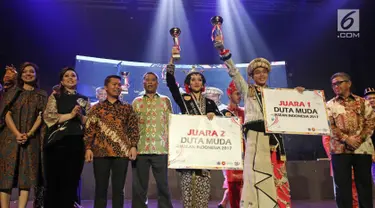 Wendra Tandribali dari DKI Jakarta dan Scholastika Asyana dari Provinsi DIY Putri mengangkat piala usai terpilih menjadi Duta Muda ASEAN-Indonesia 2017 di Balai Sarbini, Jakarta, Selasa (29/08). (Liputan6.com/Herman Zakharia)