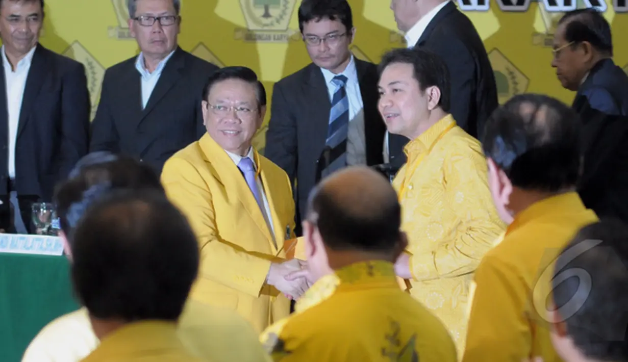 Agung Laksono memberikan berkas salinan putusan kepada Aziz Syamsuddin usai sidang putusan Mahkamah Partai Golkar di DPP Partai Golkar, Jakarta, Selasa (03/03/2015).(Liputan6.com/Andrian M Tunay)