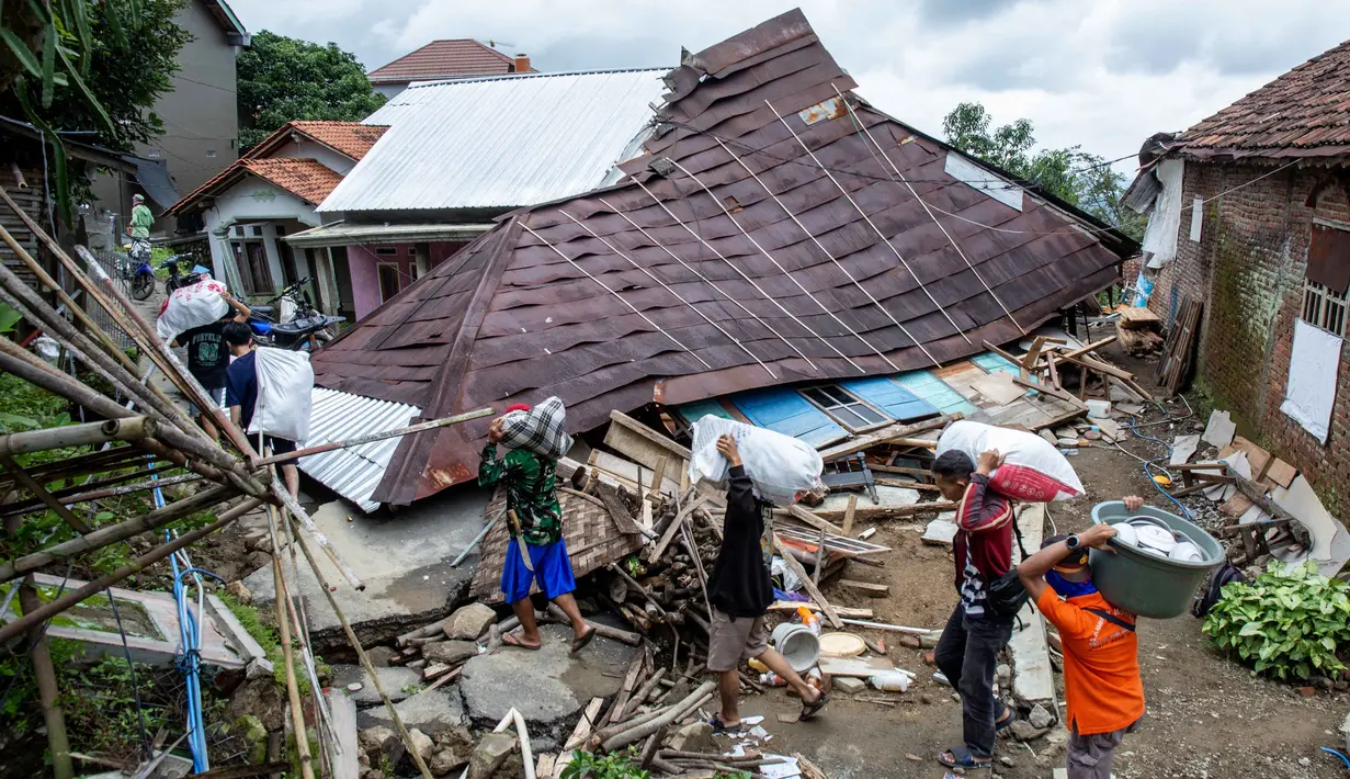 Badan Nasional Penanggulangan Bencana (BNPB) mencatat jumlah warga yang mengungsi meningkat. Tampak dalam foto, warga menyelamatkan barang-barang mereka setelah pergerakan tanah melanda permukiman mereka di desa Padasari, Tegal, Jawa Tengah, Senin 9 Februari 2026. (DEVI RAHMAN/AFP)