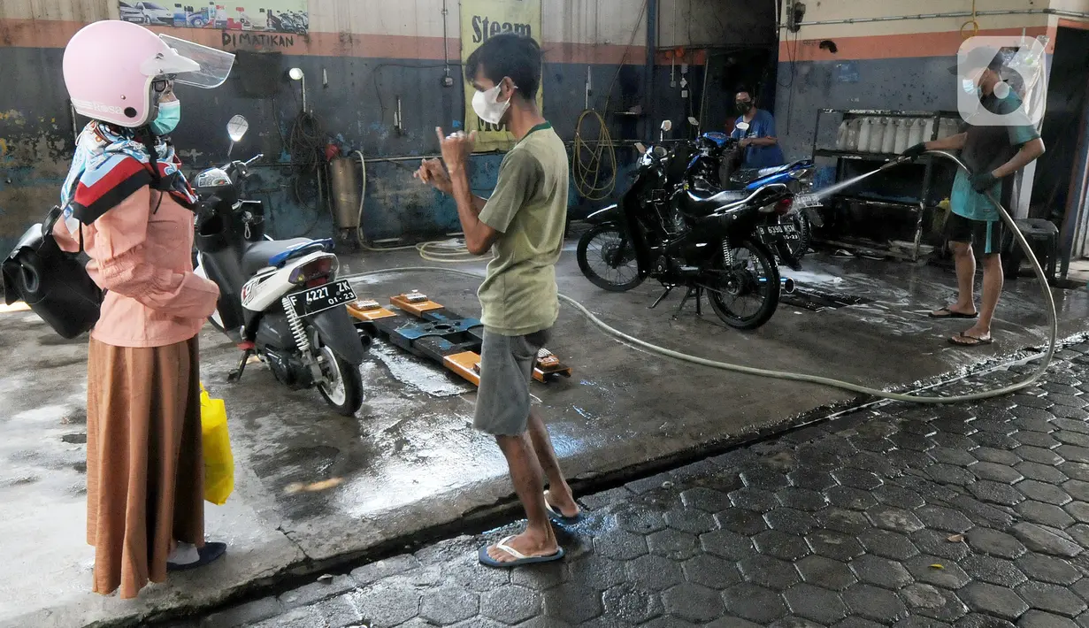 Karyawan penyandang tunarungu berkomunikasi menggunakan bahasa isyarat dengan pelanggannya di Deaf Cafe and Car Wash di kawasan Cinere, Depok, Jawa Barat, Senin (27/9/2021). Seluruh karyawan di tempat cuci mobil-motor dan kafe ini merupakan penyandang tunarungu. (merdeka.com/Arie Basuki)