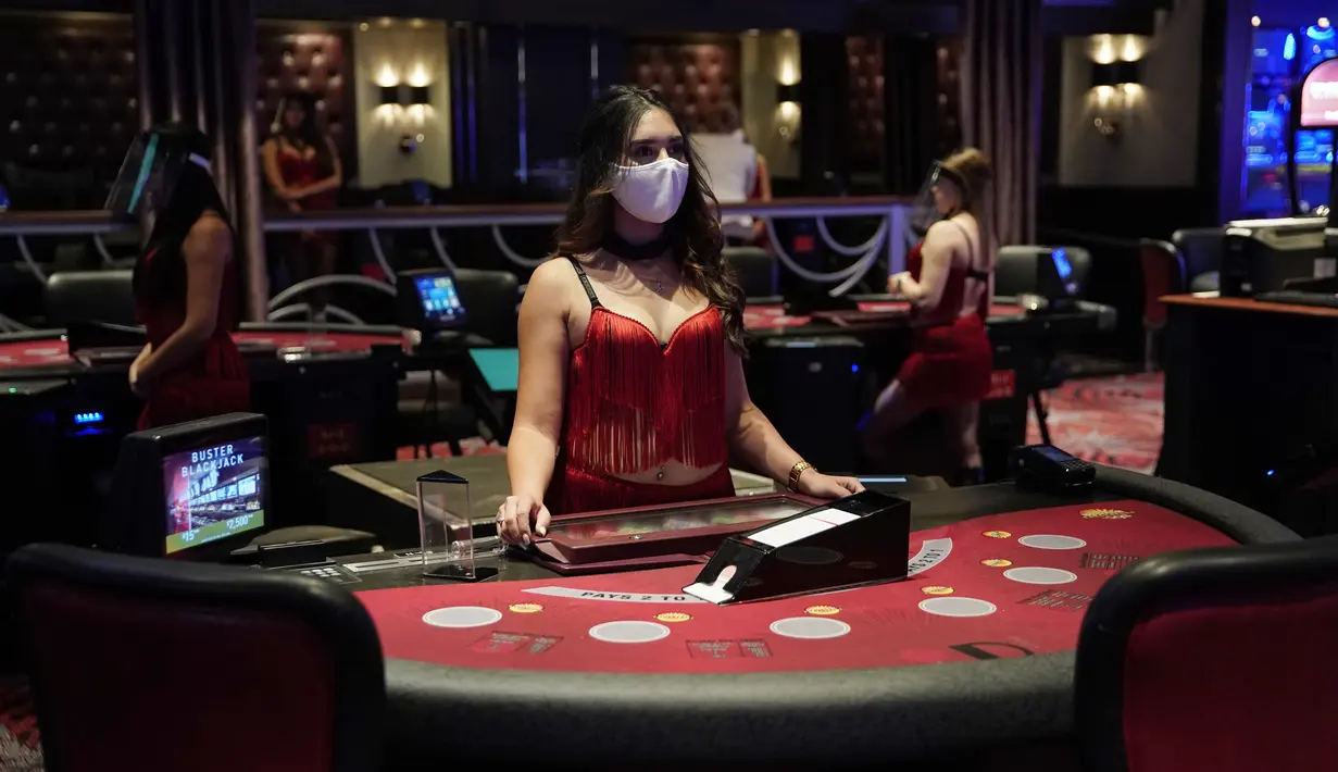 Dealer mengenakan masker saat menunggu pengunjung jelang pembukaan kembali hotel dan kasino Bellagio di Las Vegas, Nevada, Amerika Serikat, Rabu (3/6/2020). Kasino di Nevada diizinkan kembali beroperasi setelah penutupan sementara untuk mencegah penyebaran COVID-19. (AP Photo/John Locher)