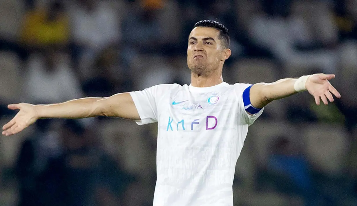 Pemain Al Nassr, Cristiano Ronaldo, melakukan selebrasi setelah mencetak gol ke gawang Al Ittihad dalam laga tunda pekan ke-17 Liga Arab Saudi di King Abdullah Sport City Stadium, Jeddah, Rabu (27/12/2023). CR7 menyumbang dua gol di laga ini. (Photo by AFP)