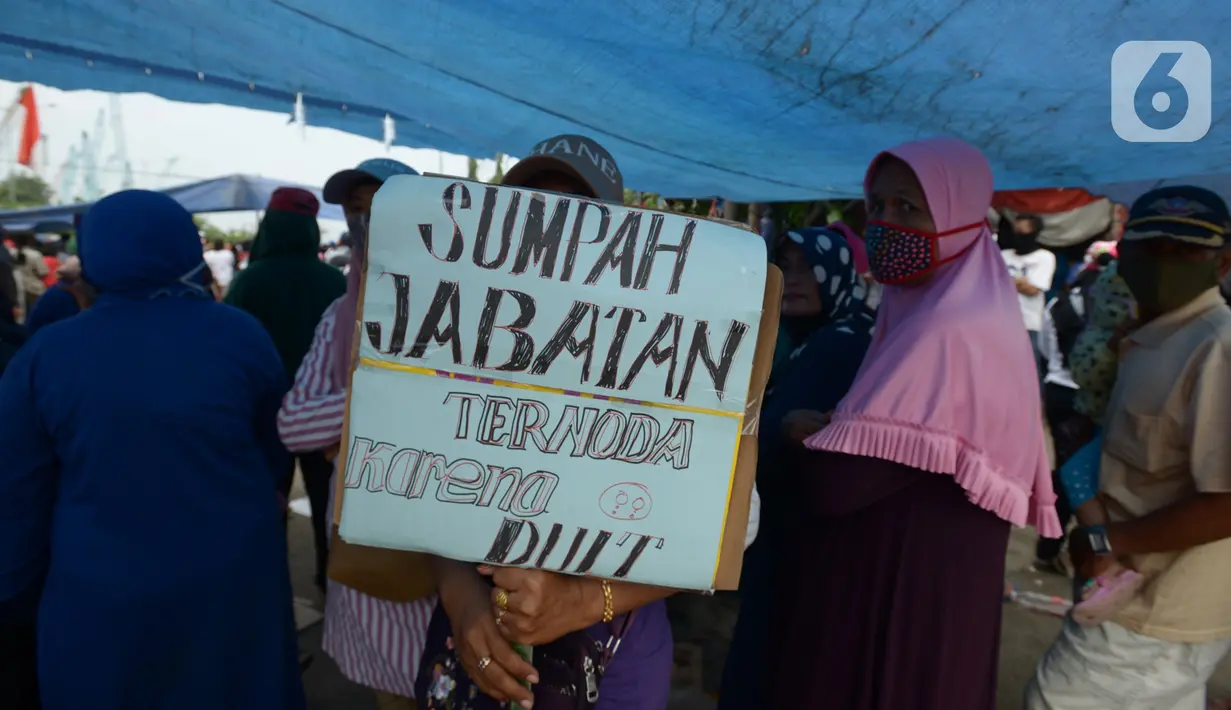 Warga Kampung Sawah melakukan aksi dengan menutup akses jalan Cakung Cilincing, Jakarta, Rabu (18/11/2020). Aksi tutup jalan ini merupakan sebagai bentuk protes warga atas hak tanahnya yang terkena proyek pembangunan jalan tol Cakung Cilincing (Cacing)-Cibitung. (merdeka.com/Imam Buhori)