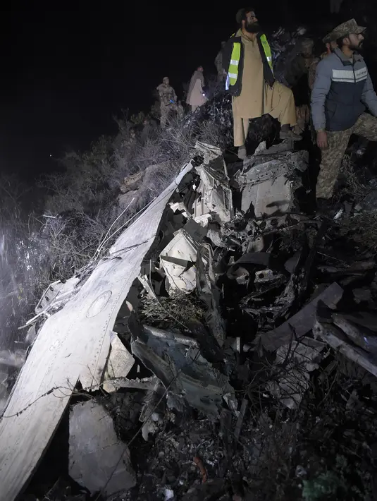 Tentara berdiri di antara puing pesawat Pakistan International Airlines (PIA) yang jatuh di Abbottabad, wilayah Khyber Pakhtunkhawa, Rabu (7/12). Di penerbangan tersebut terdapat 42 penumpang, lima awak, dan satu petugas teknis. (AAMIR QURESHI/AFP)