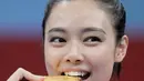 Atlet Wushu Indonesia, Lindswell Kwok mengigit medali emas usai pertandingan pada Asian Games  di JIExpo, Jakarta, Senin, (20/8). Lindswell Kwok berhasil menyumbang emas kedua untuk Indonesia di Asian Games 2018. (AP Photo/Aaron Favila)