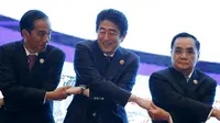 Presiden Jokowi (kiri) bergandeng tangan dengan  perdana Menteri Jepang Shinzo Abe dan Perdana Menteri Laos Thongsing Thammavong (ki-ka) pada KTT Asia Timur ( EAS ) ke 10 di Kuala Lumpur, Malaysia, (22/11). (REUTERS/Olivia Harris)