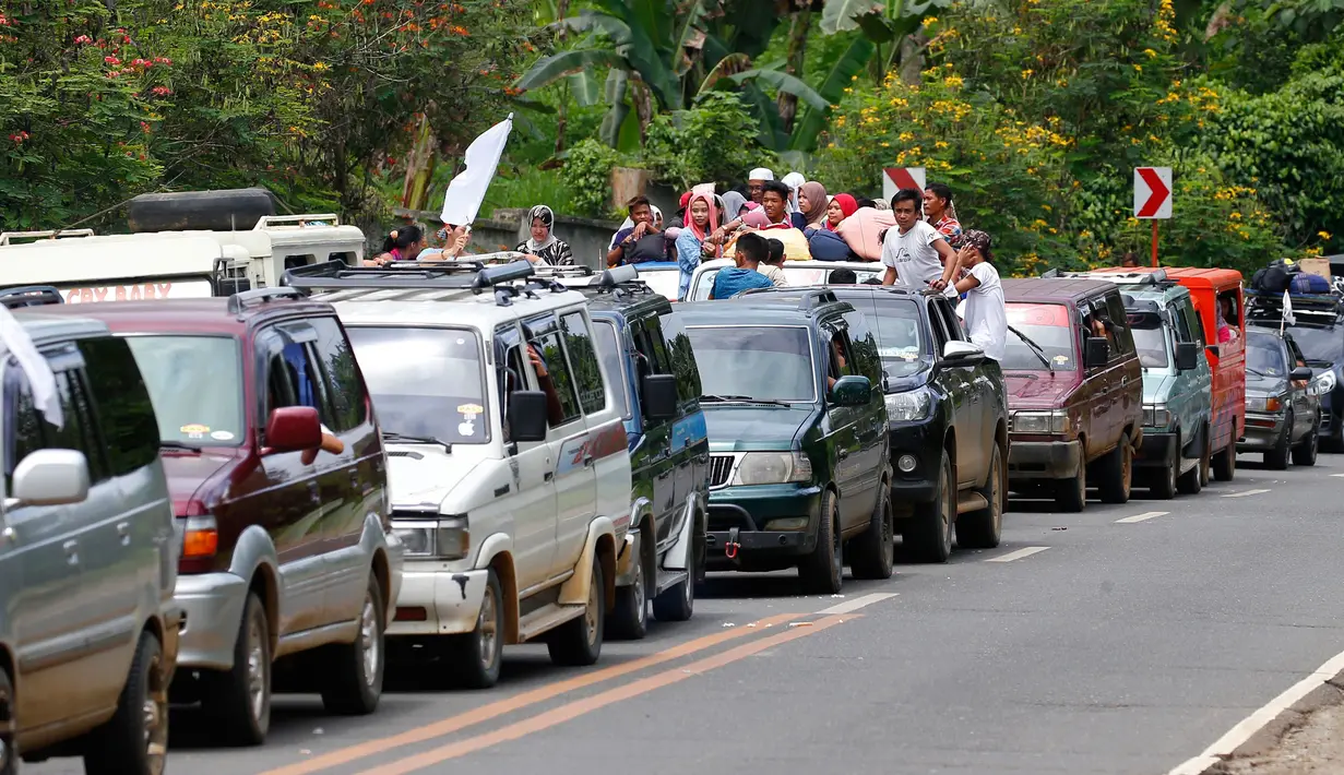 Rombongan warga Marawi yang menyelamatkan diri dari pertempuran antara pasukan pemerintah dengan kelompok Maute, Filipina, Senin (29/5). Bendera putih dipasang agar mereka tidak diserang oleh pasukan pemerintah. (AP Photo / Bullit Marquez)