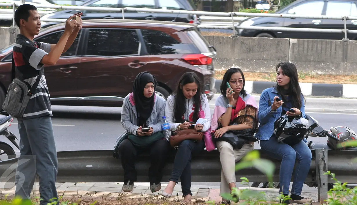 Sejumlah pegawai oulet menunggu kepastian di luar Gedung Mal Tebet Green, jakarta, Kamis (23/7/15). Mal yang dibangun sejak 2009 dan beroperasi 2011 ini tersandung masalah Sertifikat Layak Fungsi (SLF). (Liputan6.com/Herman Zakharia)
