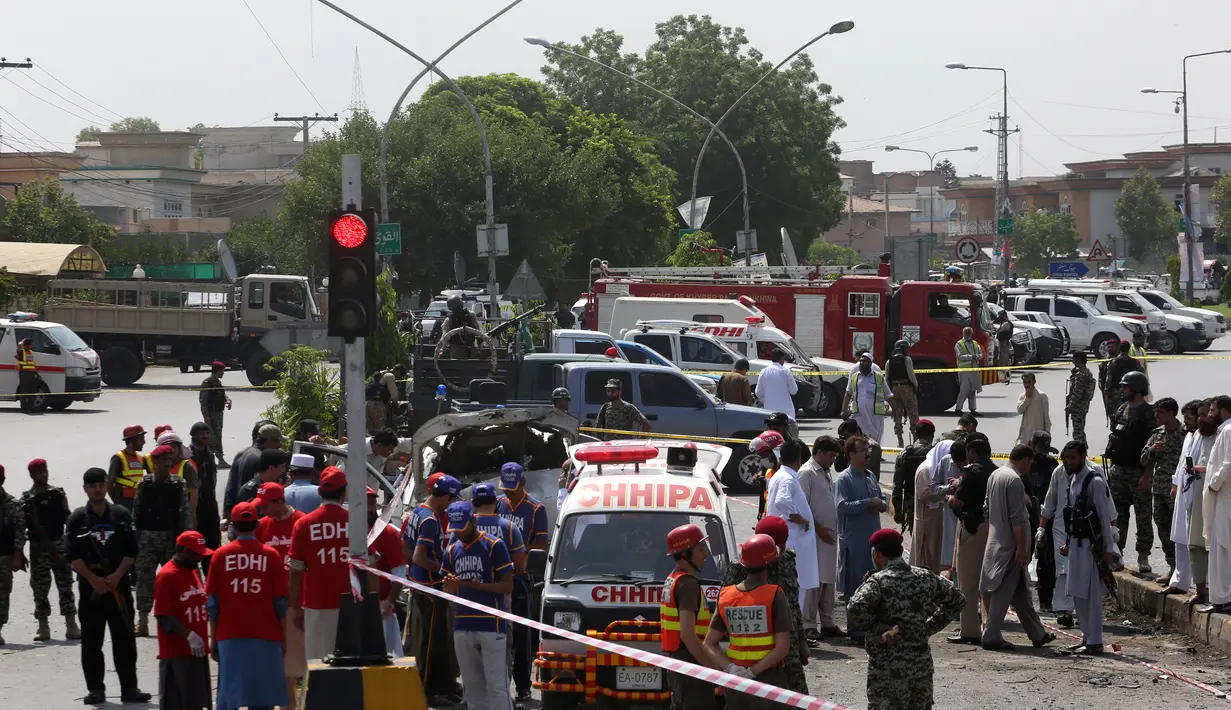 Suasana di lokasi serangan bom bunuh diri di Peshawar, Pakistan, Senin (17/7). Seorang pembom bunuh diri menyerang sebuah kendaraan yang membawa anggota paramiliter Frontier Corps (FC). (AP Photo / Muhammad Sajjad)