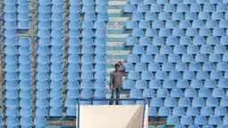 Seorang penonton berdiri sendirian dekat bangku kosong di tribun sebelum laga Persib Bandung melawan PS TNI pada lanjutan Liga 1 2017 di Stadion Si Jalak Harupat, Sabtu (05/8/2017). Persib menang 3-1. (Bola.com/Nicklas Hanoatubun)