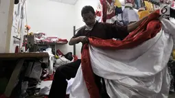 Penjahit merapikan bendera Merah Putih di Pasar Senen, Jakarta, Kamis (2/8). Salah seorang penjahit mengaku pesanan bendera Merah Putih meningkat hingga 50 persen dibandingkan bulan-bulan sebelumnya. (Merdeka.com/Iqbal Nugroho)