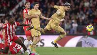 Pemain Barcelona, Ronald Araujo berusaha melewati pemain Almeria pada laga lanjutan Liga Spanyol 2022/2023 yang berlangsung di Power House Stadium, Senin (27/02/2023) dini hari WIB. (AFP/Jorge Guerrero)