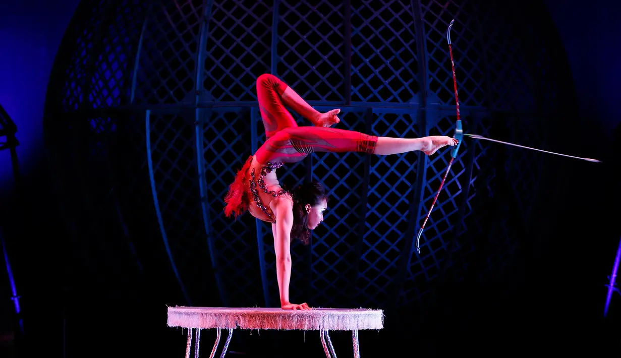 Wanita melakukan aksi dengan memegang panah dengan kakinya dengan badan terbalik saat tampil di acara Zippos Cirque Berserk di Teater Peacock, London (8/2). (REUTERS/Stefan Wermuth)
