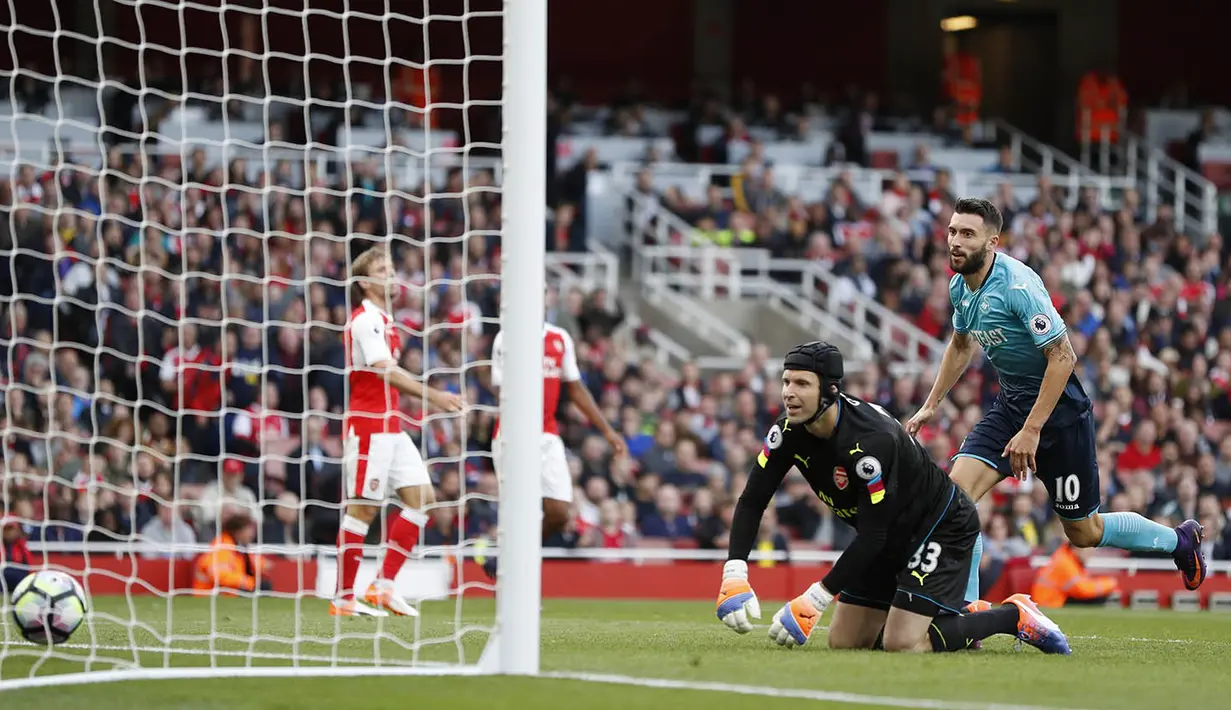 Kiper Arsenal, Petr Cech, kebobolan oleh gelandang Swansea, Borja Baston, pada laga Premier League di Stadion Emirates, London, Sabtu (15/10/2016). Arsenal menang 3-2 atas Swansea. (Reuters/John Sibley)