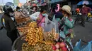 Seorang pedagang menimbang buah di sepanjang jalan karena pasar tetap tutup di tengah pembatasan lockdown yang diberlakukan untuk mencoba menghentikan lonjakan kasus virus corona COVID-19 di Phnom Penh, Kamboja, Selasa (11/5/2021). (TANG CHHIN Sothy/AFP)