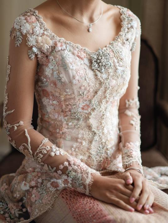 Begini detail kebaya lamaran Namira Adjani dari dekat. Anak artis lulusan S2 hukum di London ini mengenakan kebaya modern transparan warna putih dengan bordir bunga warna putih dan pink. Detail kerah berbentuk U membuatnya makin anggun. Meski model dan bordiran kebayanya simpel, namun sangat elegan dan cocok dikenakan oleh sepupu Alika Islamadina ini. (Liputan6.com/IG/@namiradjani)