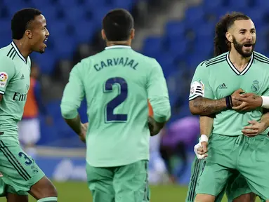 Para pemain Real Madrid merayakan gol yang dicetak oleh Karim Benzema ke gawang Real Sociedad pada laga La Liga di Reale Seguros Stadium, Minggu (21/6/2020). Real Madrid menang 2-1 atas Real Sociedad. (AP Photo/Alvaro Barrientos)