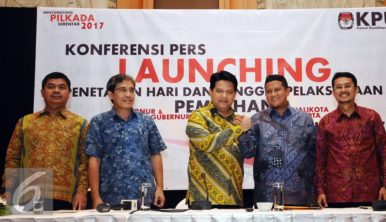 Ketua KPU Husnin Kamil Manik (tengah) bersalaman dengan Ketua Bawaslu Muhammad usai memberikan keterangan Pilkada Serentak 2017 di Jakarta, Senin (15/2/2016). Pilkada Serentak 2017 akan dilaksanakan Rabu 15 Februari 2017. (Liputan6.com/Helmi Fithriansyah)
