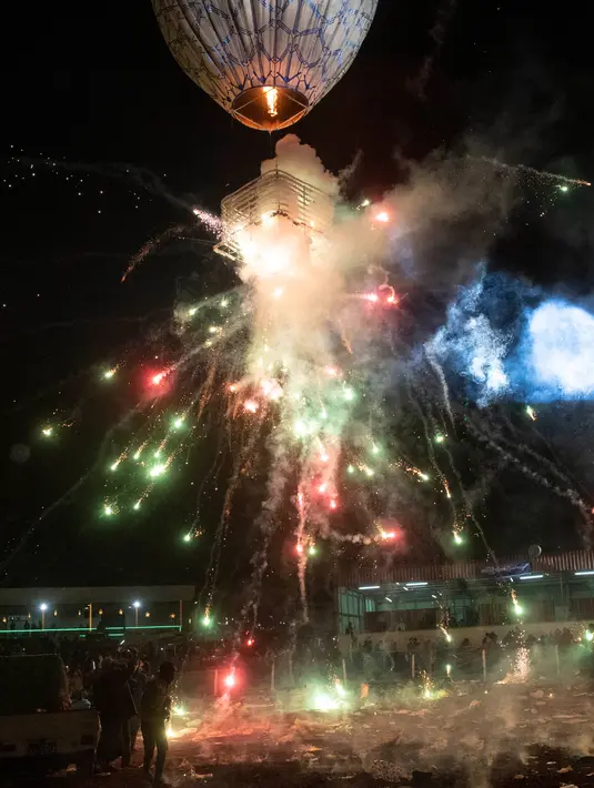 Peserta melepaskan balon udara yang membawa lentera kecil selama Festival Tazaungdaing di Taunggyi, Myanmar pada 14 November 2018. Festival tahunan itu diselenggarakan guna merayakan berakhirnya musim hujan. (Ye Aung THU / AFP)