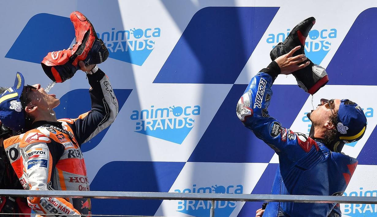 Pembalap Spanyol dari tim Repsol Honda, Marc Marquez (kiri) bersama Alex Rins (Suzuki Ecstar) merayakan kemenangan Grand Prix MotoGP Australia di Sirkuit Phillip Island, Minggu (16/10/2022). Marc Marquez finish di posisi kedua dan ini menjadi podium pertamanya sejak kembali pasca operasi keempat cedera patah lengan tangan kanan. (Paul CROCK/AFP)