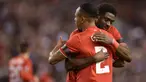Pemain Liverpool, Kolo Toure, berpelukan dengan rekannya Nathaniel Clyne usai menaklukan Bordeaux pada laga Liga Europa di Stadion Anfield, Inggris, Kamis (26/11/2015). Liverpool berhasil menang 2-1. (AFP Photo/Oli Scarff)
