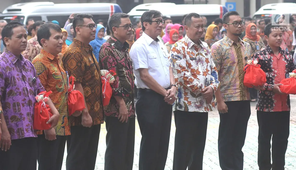 Menkumham Yasona Laoly berpose bersama jelang melepas ratusan pegawai dan keluarganya untuk mudik bersama ke kampung halaman, Jakarta (22/6). Ada 5 bus yang digunakan dalam mudik bersama ini. (Liputan6.com/Helmi Afandi) 
