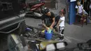 Saat tidak ada pertunjukkan, dirinya bekerja di bengkel sambil menginspirasi anak muda lain yang mau mengikuti jejaknya dengan cara mengajari mereka untuk mengganti oli dan tune up motor. (Foto: AP/Matias Delacroix)