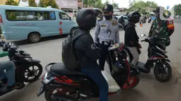 Petugas melakukan pengecekan kepada pengendara di pos chek point, Kalimalang Lampiri, Jakarta, Rabu (27/5/2020). Chek point penyekatan kendaraan yang hendak masuk ke wilayah Jakarta tersebar di 11 titik Kabupaten Bogor, Bekasi dan Tangerang untuk pemeriksaan SIKM. (merdeka.com/Imam Buhori)