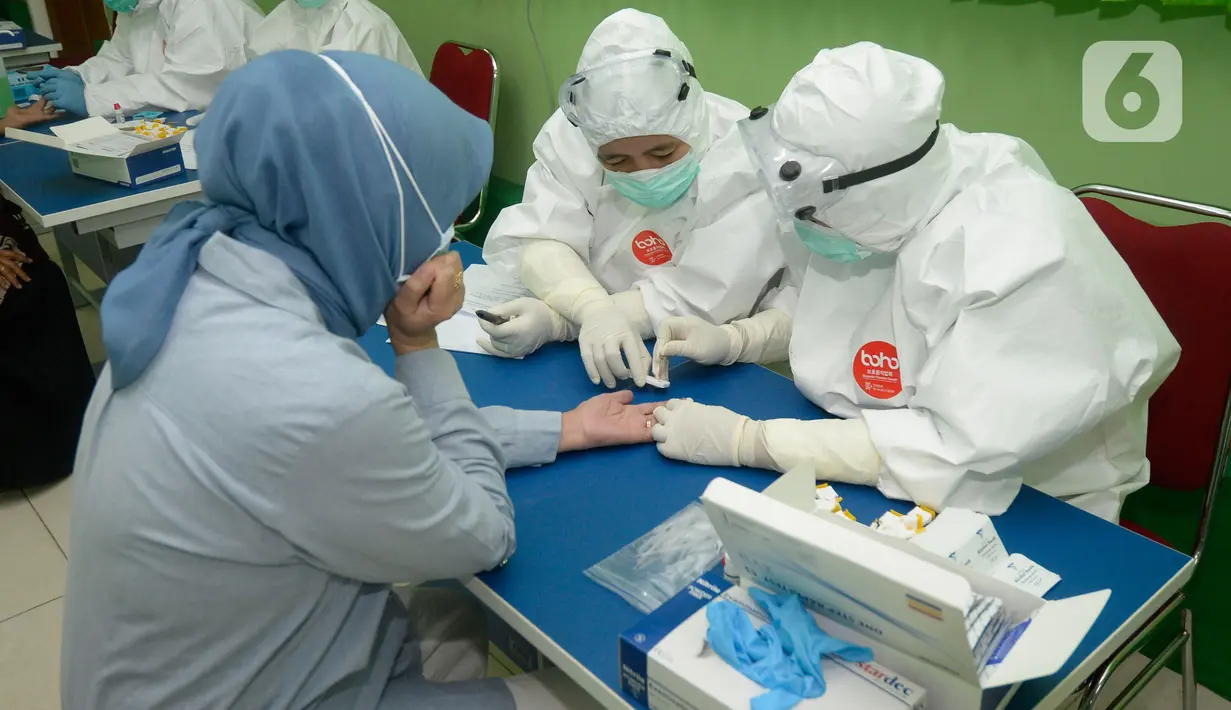 Tenaga pendidik SMP mengikuti tes pemeriksaan cepat COVID-19 (Rapid Test) di SMPN 3 Ciputat, Tangerang Selatan, Kamis (27/08/2020). Rapid tes yang diikuti 400 guru mencakupi wilayah Ciputat dan Ciputat Timur itu untuk mencegah penyebaran Covid-19 di lingkungan pendidikan. (merdeka.com/Dwi Narwoko)