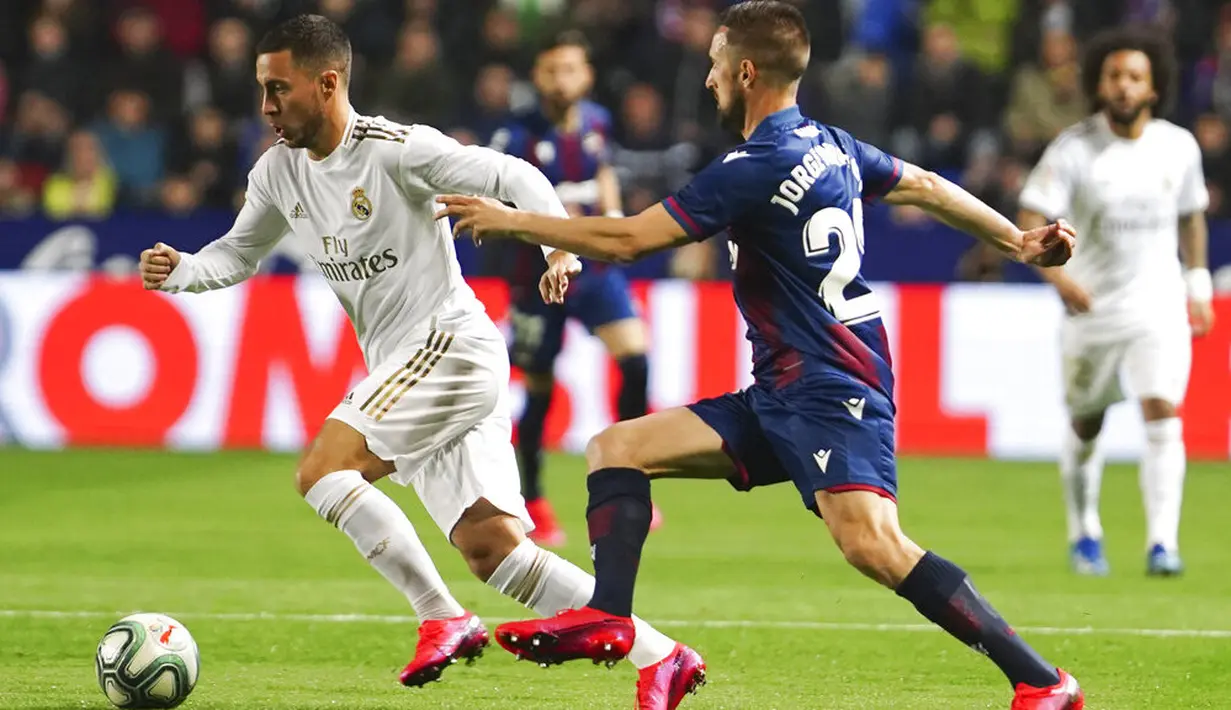 Gelandang Real Madrid, Eden Hazard, berusaha melewati pemain Levante, Jorge Miramon, pada laga La Liga di Stadion Ciutat de Valencia, Sabtu (22/2/2020). Levante menang 1-0 atas Real Madrid. (AP/Alberto Saiz)