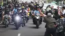 Presiden Joko Widodo menyapa warga saat berkendara dengan motor Kawasaki W175 miliknya mengelilingi Kota Bandung, Minggu (11/10). Jokowi memimpin rombongan pengendara sepeda motor dari berbagai komunitas menuju Jalan Braga. (Liputan6.com/Angga Yuniar)