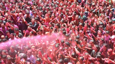 Umat Hindu India disemprot dengan cairan berwarna dalam festival keagamaan Holi di Kuil Swupramayan Kalupur, Ahmedabad, Rabu (20/3). Holi merupakan festival Hindu terbesar di India yang menandai dimulainya musim semi. (SAM PANTHAKY / AFP)