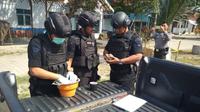 Tim Jibom dan Gegana Polda Jateng mengecek benda diduga granat yang ditemukan seorang petani di Puring, Kebumen. (Liputan6.com/Dok. Polres Kebumen untuk Muhamad Ridlo)