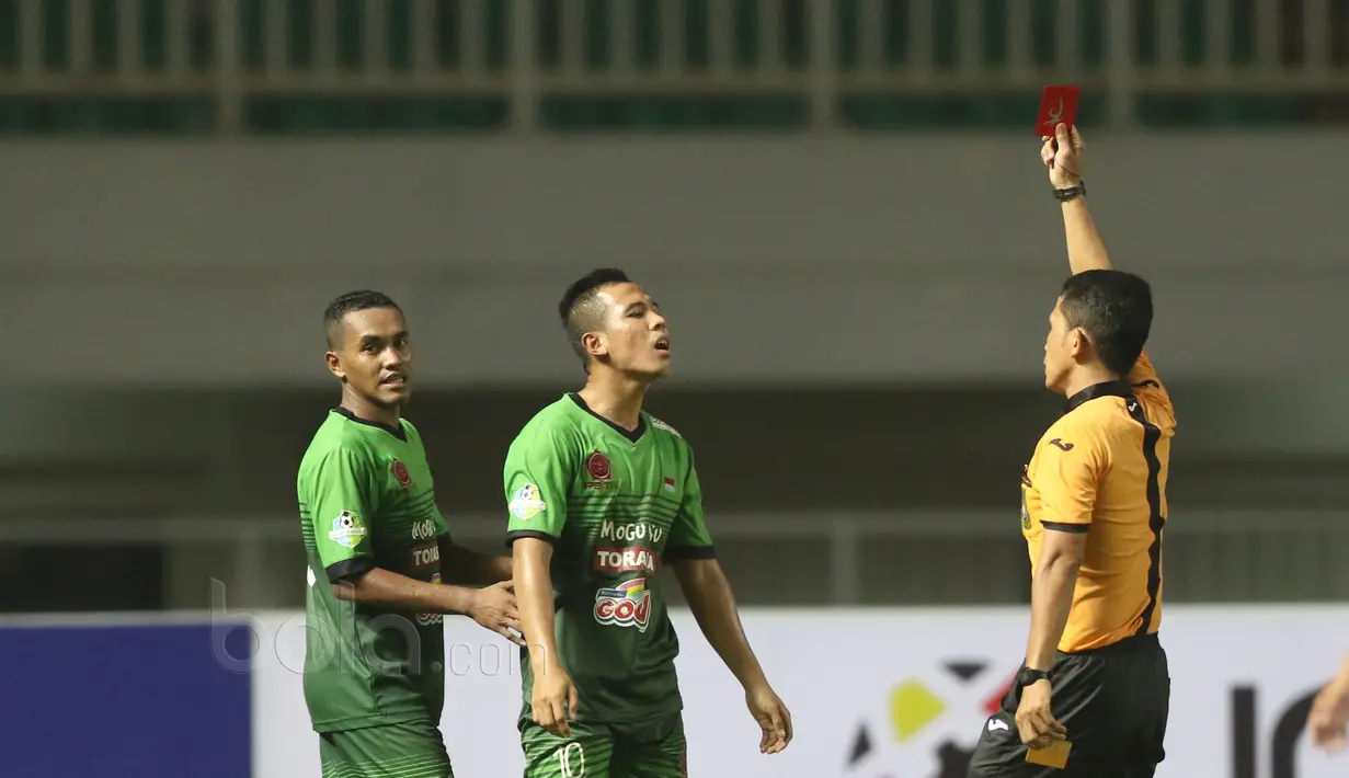 Pemain PSTNI, Guntur Triaji (tengah) menerima kartu merah saat melawan Persela Lamongan pada Liga 2017 di Stadion Pakansari, Bogor, Sabtu (27/5/2017). PS TNI menang 3-2. (Bola.com/Nicklas Hanoatubun)