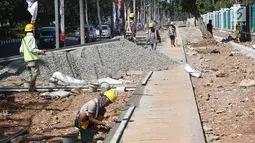 Suasana penyelesaian pembuatan trotoar di kawasan Senayan, Jakarta, Senin (28/8). Pembuatan trotoar dilakukan dalam rangka menyambut event Asian Games 2018 mendatang yang akan digelar di Jakarta dan Palembang. (Liputan6.com/Immanuel Antonius)