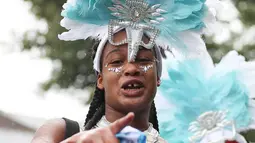 Seorang penari ambil bagian pada parade hari pertama Karnaval Notting Hill di London barat, Minggu (26/8). Ratusan ribu orang tumplek ke jalan menikmati warna-warni dan musik yang tak berhenti dimainkan. (AFP/Daniel LEAL-OLIVAS)