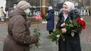 Seorang aktivis berhijab memberikan bunga kepada seorang perempuan pejalan kaki untuk memperingati World Hijab Day atau Hari Hijab Sedunia di Kyiv, Ukraina, Senin (1/2/2021). Hari Hijab Sedunia merupakan gagasan Nazma Khan di New York, Amerika Serikat pada tahun 2013. (AP Photo/Efrem Lukatsky)