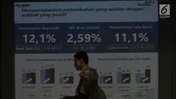 Pegawai melintas di balik layar saat paparan kinerja Bank Mandiri triwulan II-2019 di Jakarta, Rabu (17/7/2019). Kualitas kredit Bank Mandiri juga membaik dengan NPL gross pada 2,59%, turun 54 bps dari Juni 2018. (Liputan6.com/Angga Yuniar)