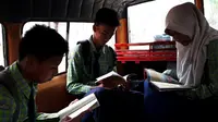 Udin (49) membangun perpustakaan di dalam angkotnya. (Liputan6.com/Yandhi Deslatama)