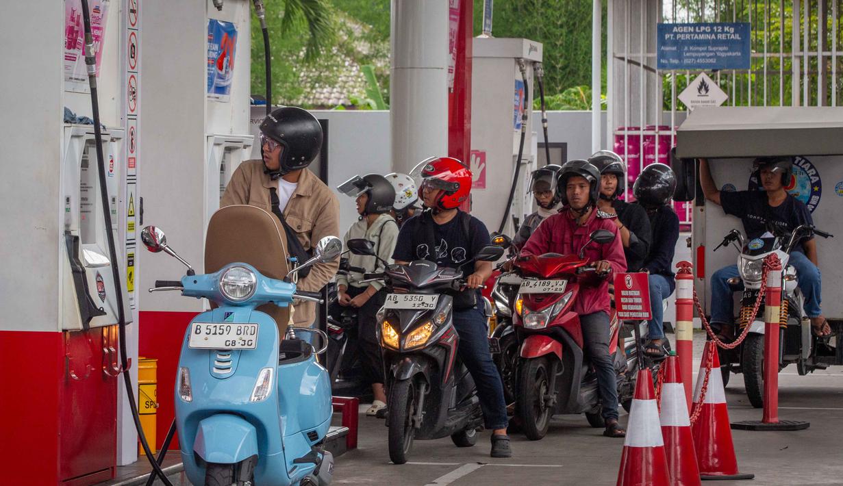 Kondisi ini turut mendorong penyesuaian harga bahan bakar minyak (BBM) secara global, termasuk Indonesia, secara bertahap. Tampak dalam foto, para pengendara sepeda motor mengantre untuk mengisi bahan bakar di sebuah Stasiun Pengisian Bahan Bakar Umum (SPBU) yang dioperasikan oleh Pertamina, perusahaan minyak dan gas milik negara Indonesia, di Yogyakarta, pada Sabtu 28 Maret 2026. (DEVI RAHMAN/AFP)