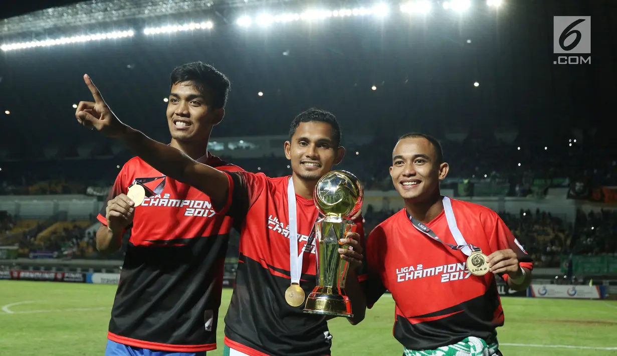 Pemain Persebaya berfoto bersama piala Liga 2 saat merayakan kemenangan usai menumbangkan PSMS Medan di Final Liga 2 Indonesia di Stadion GBLA, Bandung, Selasa (28/11). Persebaya unggul 3-2 atas PSMS Medan. (Liputan6.com/Helmi Fithriansyah)