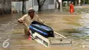 Warga menerobos banjir di kawasan komplek Polri jalan Pondok Karya, Mampang, jakarta, kamis (21/4). Akibat pintu air di Depok dibuka kali mampang meluap dan menyebabkan banjir di kawasan tersebut. (Liputan6.com/Gempur M Surya)