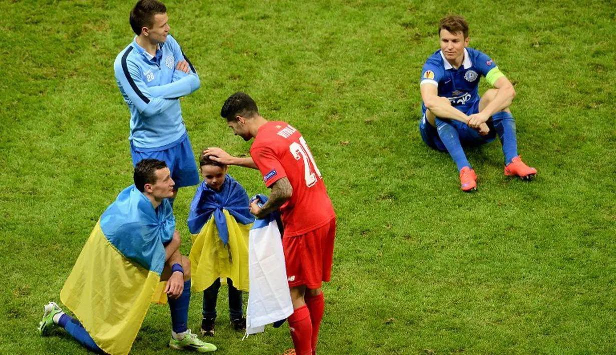 Pemain Sevilla, Vitolo, berusaha menghibur pemain Dnipro. (AFP PHOTO/JANEK SKARZYNSKI)