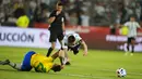 Pemain Argentina Lionel Messi (kanan) dilanggar oleh pemain Brasil Matheus Cunha pada pertandingan sepak bola kualifikasi Piala Dunia 2022 di Stadion Bicentenario, San Juan, Argentina, 16 November 2021. Pertandingan berakhir dengan skor 0-0. (AP Photo/Natacha Pisarenko)