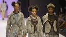 Tiga model berjalan di catwalk mengenakan busana kreasi Maxivive selama Heineken Fashion and Design Week di Lagos, Nigeria (26/10/2019). Lagos Fashion Week (LFWNG) adalah acara mode multi-hari tahunan yang didirikan pada 2011 oleh Omoyemi Akerele. (AP Photo/Sunday Alamba)