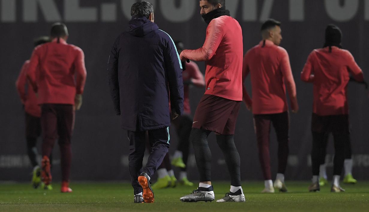 Luis Suarez tampak berdiskusi dengan Valverde dalam sesi latihan jelang laga lanjutan grup B Liga Champions yang berlangsung di stadion Camp Nou, Spanyol, Rabu (12/12). El Barca akan ditantang Tottenham Hotspur. (AFP/Lluis Gene)