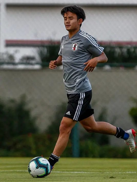 Gelandang Jepang, Takefusa Kubo menggiring bola saat sesi latihan jelang turnamen Copa America 2019 di Sao Paulo, Brasil (13/6/2019). Pemain berusia 18 tahun akan masuk ke dalam skuad tim B Madrid, Castilla, untuk musim depan. (AFP Photo/Miguel Schincariol)