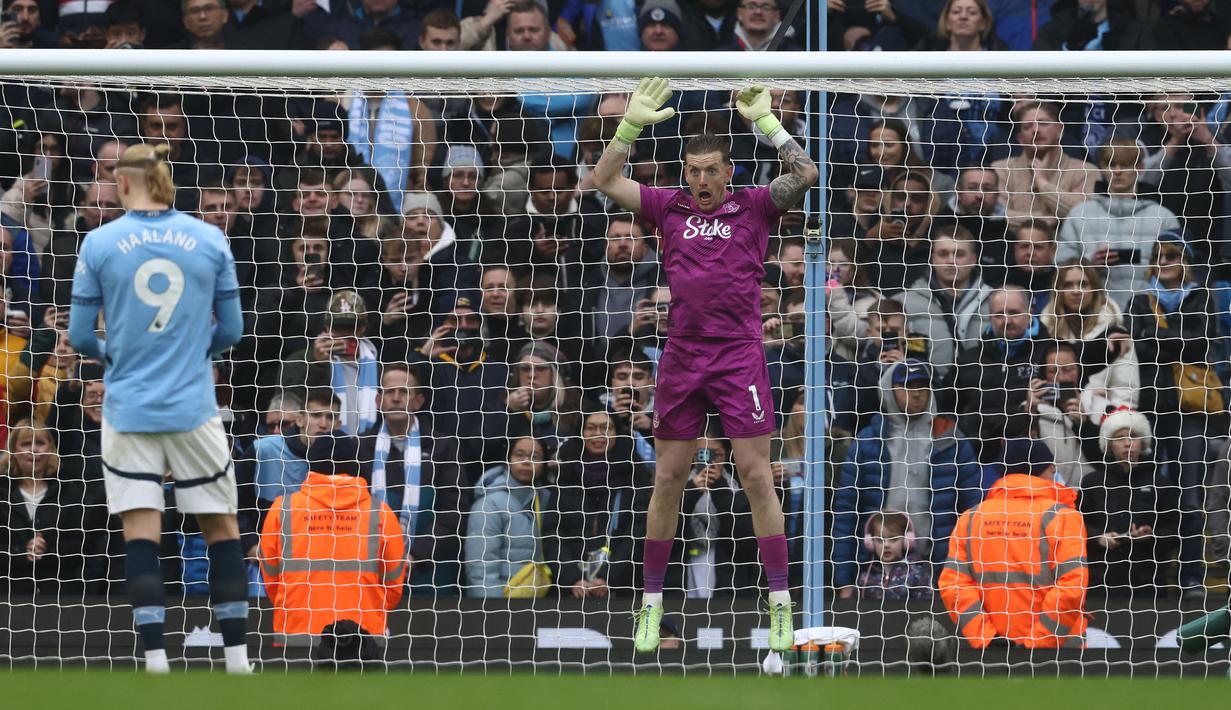 Kiper Manchester City, Jordan Pickford (kanan) melakukan psywar saat pemain Manchester City, Erling Haaland bersiap melakukan tendangan penalti pada laga lanjutan Liga Inggris 2024/2025 di Etihad Stadium, Manchester, Inggris, Kamis (26/12/2024). (AFP/Darren Staples)
