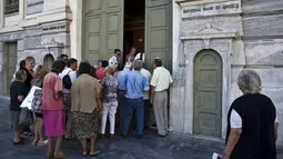Sejumlah Orang menunggu giliran untuk masuk ke Bank Nasional di Athena, Yunani (20/7/2015). Meskipun telah kembali beroperasi, namun pembatasan masih terjadi, seperti untuk transaksi transfer ke luar negeri. (REUTERS / Ronen Zvulun)